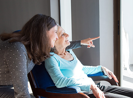 Caregiver providing emotional support and companionship to a smiling senior at home in Reston.