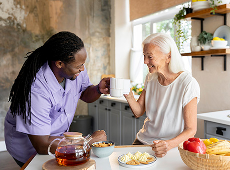 Caregiver helping an elderly person with meal preparation and feeding in a home care setting in Reston.